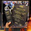 Certificate of Appreciation for 'Best Emerging Eye Makeup Brand in India' held in front of a blurred background with architectural elements.